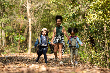 Group family children walking for explore and find directions in the camping jungle nature and adventure. Tourism kids travel for destination and leisure trips for education and relax in nature park