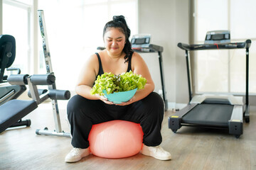 Asian woman eating healthy food salad before fitness exercise for lose weight.  People overweight...
