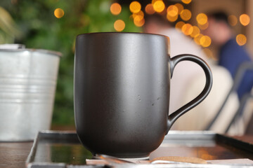 black color coffee mug mockup on table at cafe background 