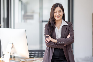 Portrait of successful confident female professional manager standing with arms crossed, young asian business woman or freelancer standing near work desk in office,  - obrazy, fototapety, plakaty