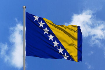 Bosnia and Herzegovina flag fluttering in the wind on sky.