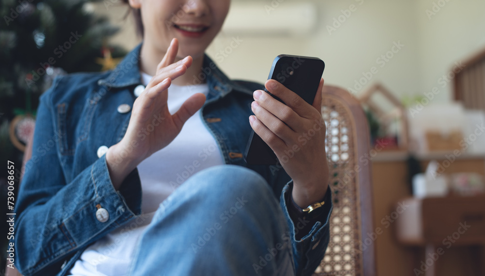 Poster Asian business woman in blue jeans using mobile phone for video calling at coffee shop