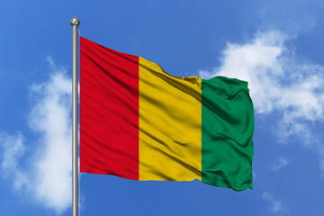 Guinea flag fluttering in the wind on sky.
