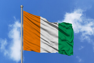 Naklejka na ściany i meble Ivory Coast flag fluttering in the wind on sky.