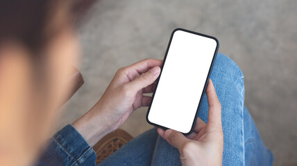 Cell phone white screen mockup, woman's hands holding mobile phone with blank screen on thigh and, overhead view. space for advertise, social media marketing design - obrazy, fototapety, plakaty