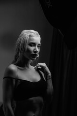 Fototapeta premium Portrait of a young girl with blond hair in a dressing gown in a low key.