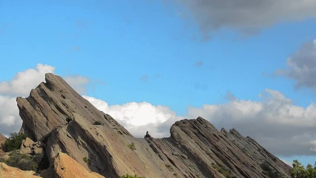 Vasquez Rocks Natural Area Park in California, amazing rock formation timelapse with floating clouds and people hiking, and cloud shadows