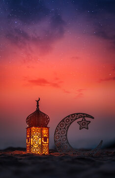 Crescent moon shape and lantern lamp on the beach with dramatic sky on the background, Ramadan Kareem and Eid Mubarak concept background
