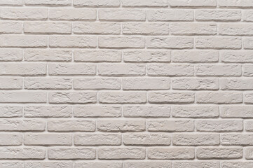 The background is a white texture of a brick wall