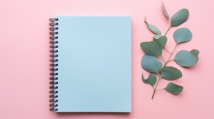 Chic blue notebook featuring eucalyptus leaves on a vibrant pink background. Ai Generated