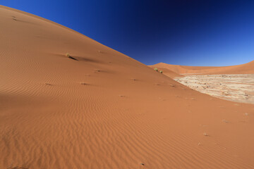 red desert sand dunes with steel blue sky
