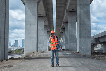 Confident construction engineer in hardhat on Site under development. Construction engineers...