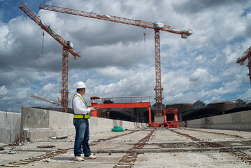 Confident construction engineer in hardhat on Site under development. Construction engineers...