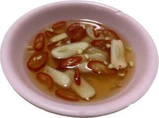 Garlic and red chili fish sauce in small pink cups placed on isolated background, sauce for thai rice street food 