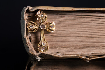 Gold and diamond cross set in an old book beautifully illuminated