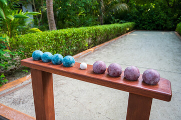 Petanque balls and a playground surrounded by a tropical forest.
