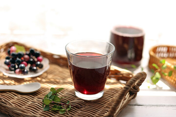 藤トレイにグラスに注いだグレープジュース