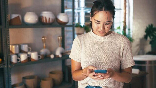 Woman, pottery studio and online artist or small business entrepreneur for craft skill, cellphone sales or diy communication. Female person, digital device and ceramic product, handmade or shop owner