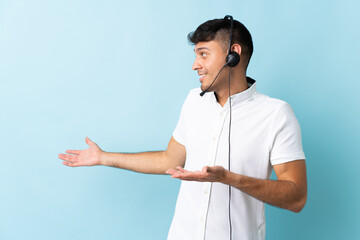 Telemarketer Colombian man working with a headset over isolated background with surprise expression...