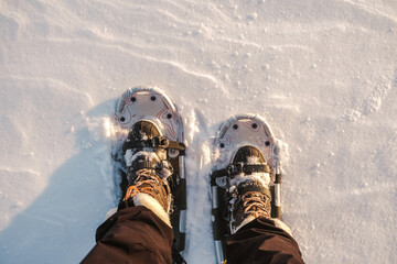 Snowshoes on feet on snow close-up