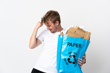 Young blonde man holding a recycling bag full of paper to recycle isolated on white background...