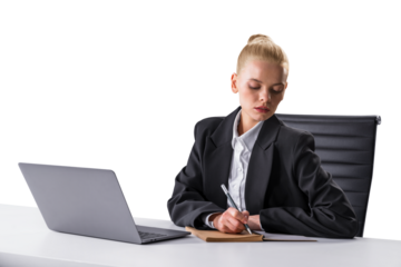 Professional woman in business attire writing at desk with laptop, office environment concept