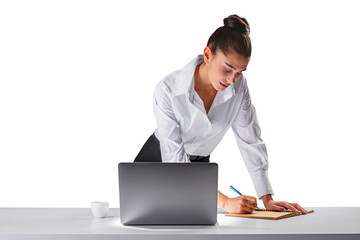 Concentrated young woman bending over desk writing, laptop beside, office work concept