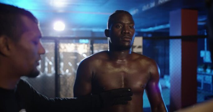 Man, arena and referee in fight night or professional match for sports competition with opponent at gym. Male person, athlete or people in boxing ring listening to rules before fighting challenge
