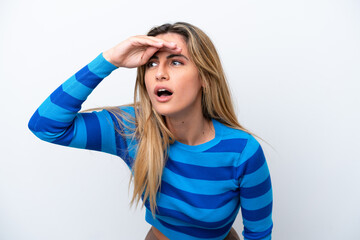 Young caucasian woman isolated on white background looking far away with hand to look something