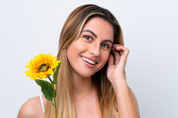Young caucasian woman isolated on white background holding a sunflower while smiling. Close up portrait
