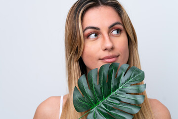 Young caucasian woman isolated on white background holding a palm leaf. Close up portrait