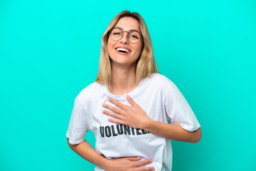 Young volunteer Uruguayan woman isolated on blue background smiling a lot