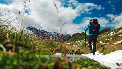 Hiker man on idyllic hiking trail with panoramic view of majestic mountain peaks in High Tauern...