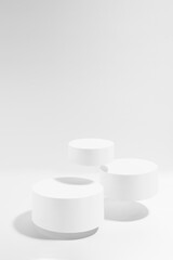 Three white round podiums soar in hard light, set, mockup on white background. Template for presentation cosmetic products, gifts, goods, advertising, design, display, showing in black friday style.