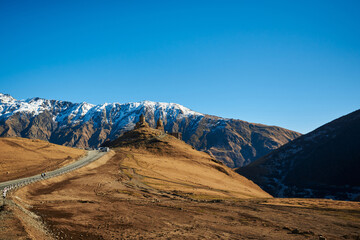 Snow-crowned mountains appearing like giants against the backdrop of a pure blue sky.