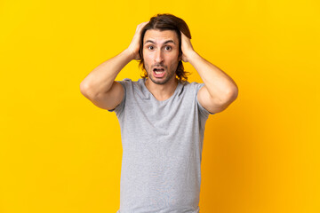 Young handsome man isolated on yellow background doing nervous gesture