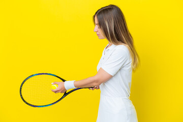 Young Romanian woman isolated on yellow background playing tennis