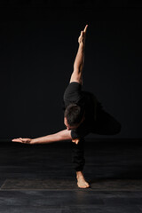  Clad in sleek black attire, the stunning yogi crafts a masterpiece of movement on his mat, each...