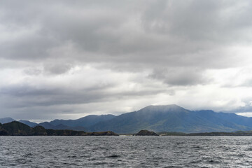 Yacht sailing on the horizon near the beach on the ocean ina  remote beautiful landscape, Tasmania, Australia and new zealand