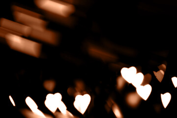 Blurry lights on a dark background. Festive bokeh background in the form of hearts for Valentine's...
