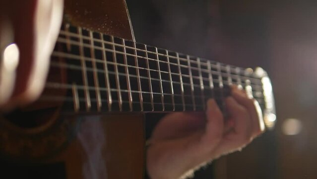 close up of a hand playing guitar