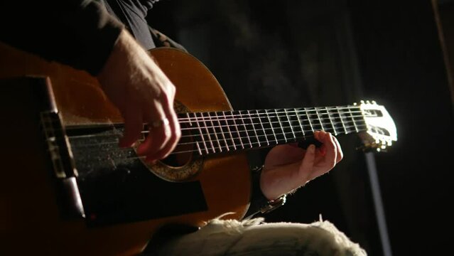 musician playing acoustic guitar close-up
