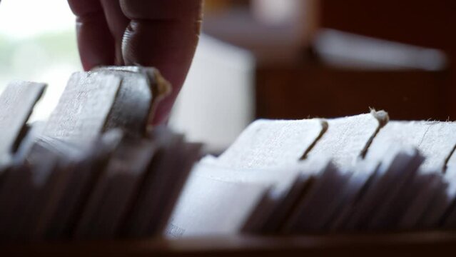 fingers go through documents in a file cabinet close-up