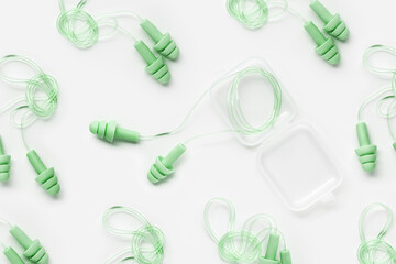 Green color earplugs as minimal trend pattern on white, reusable silicone, rubber ear plug in box...