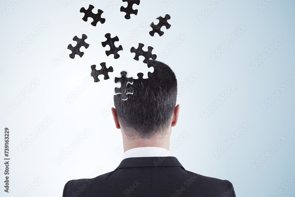 Poster Back view of puzzle headed thoughtful businessman portrait on light background with mock up place. Solution, decision and brainstorm concept.