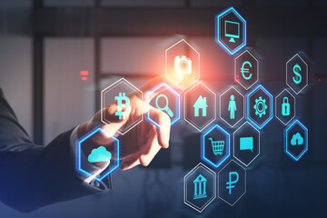 Close up of businessman hand pointing at abstract hexagonal pattern hologram with various business icons on blurry office interior background. Digital dashboard and data concept. Double exposure.