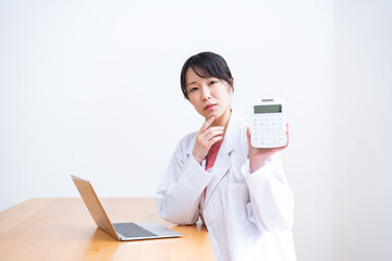 電卓を持ちカメラ目線の女性医師