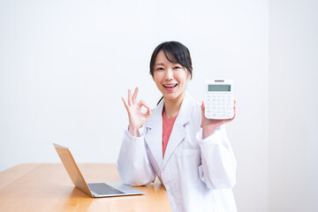 電卓を持ち笑顔の女性医師