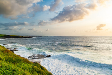 Sunset view of Mullaghmore Head with huge waves rolling ashore. Picturesque scenery with rocky...