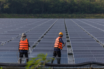Worker Cleaning  floating solar panels or solar cell Platform system on the lake with brush and water. Worker cleaning solar modules in a Solar Energy Power Plant
